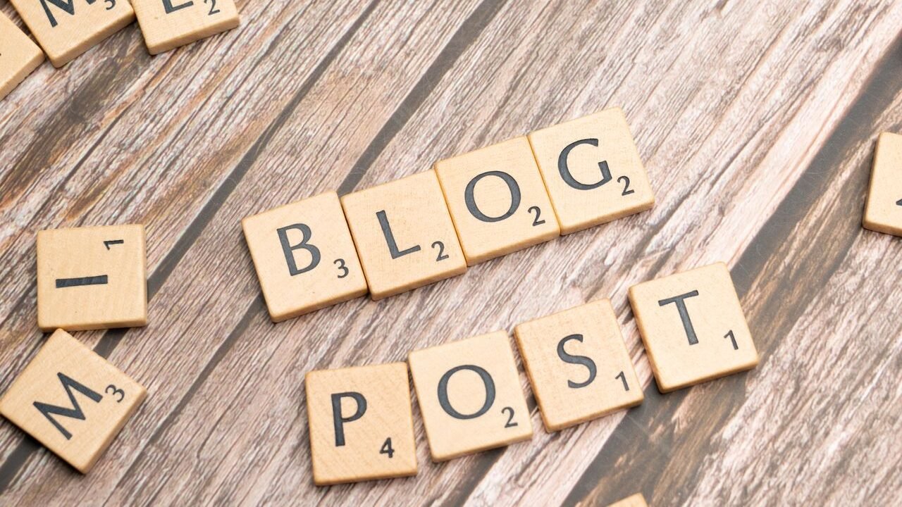 Wooden letter tiles spelling 'Blog Post' on a wooden background, ideal for online media concepts.